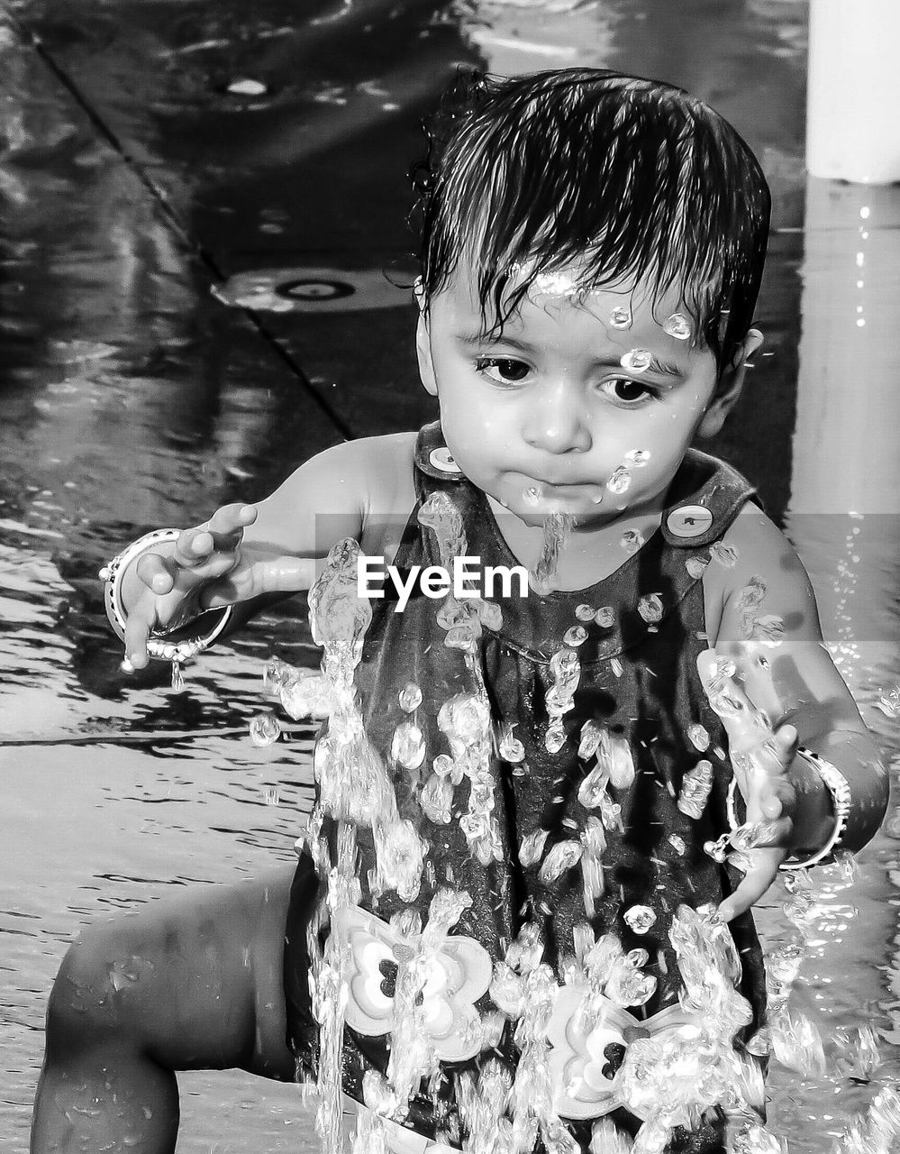 Girl playing in water from sprinkler