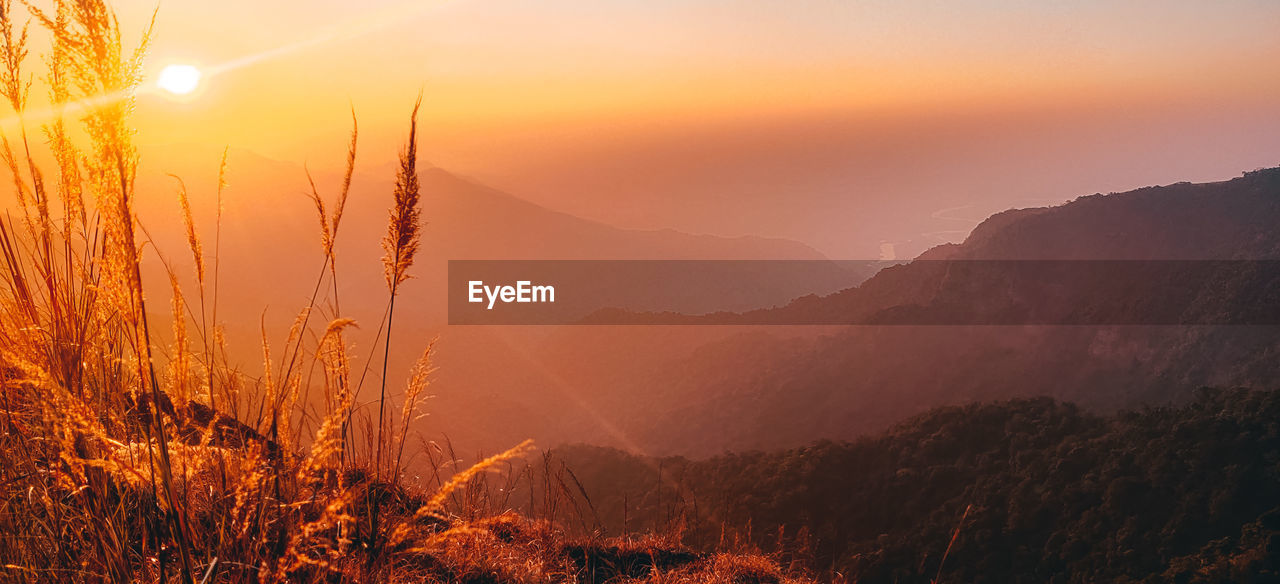 scenic view of mountains against sky at sunset