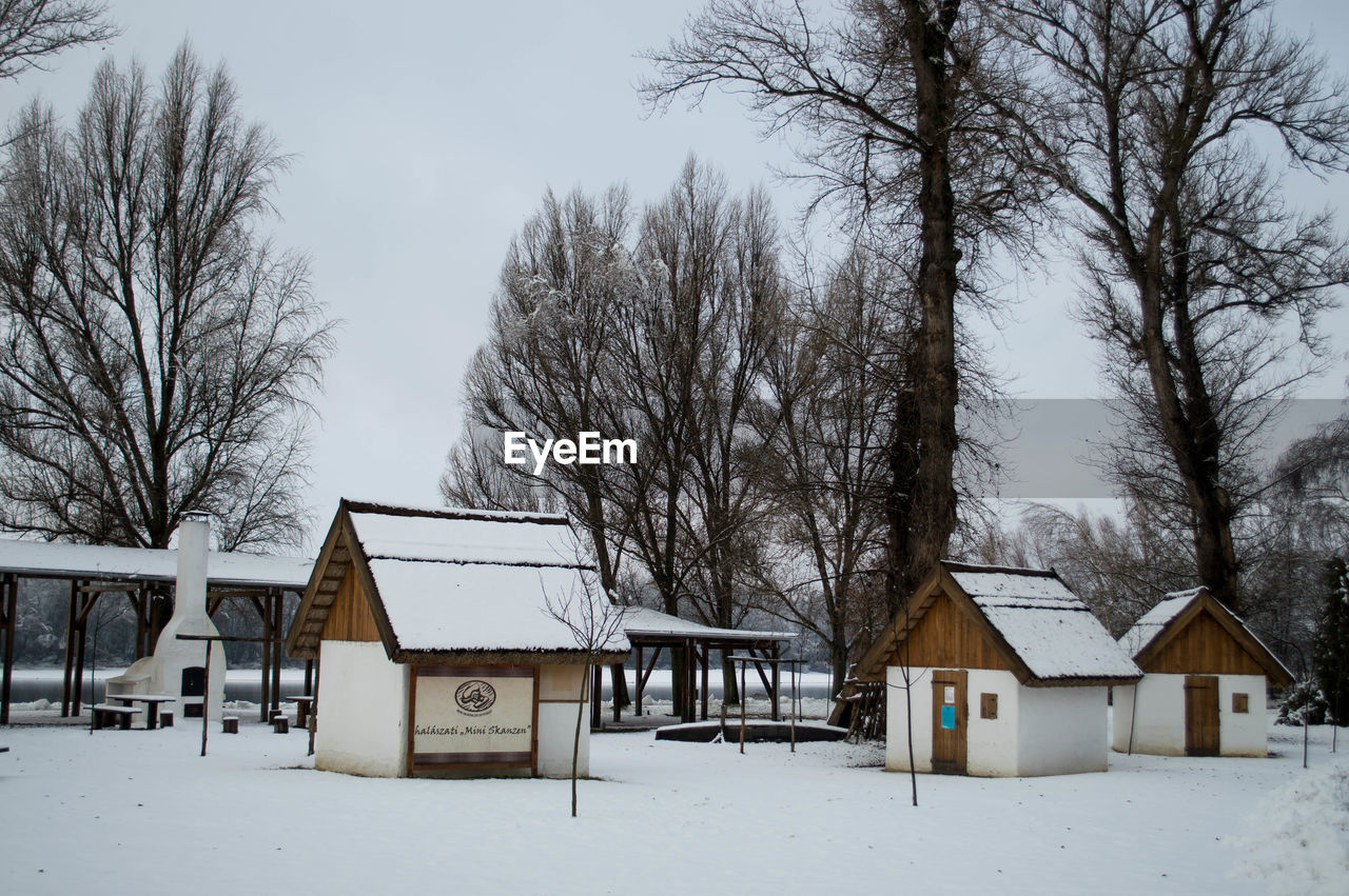 SNOW COVERED LANDSCAPE WITH HOUSES IN BACKGROUND