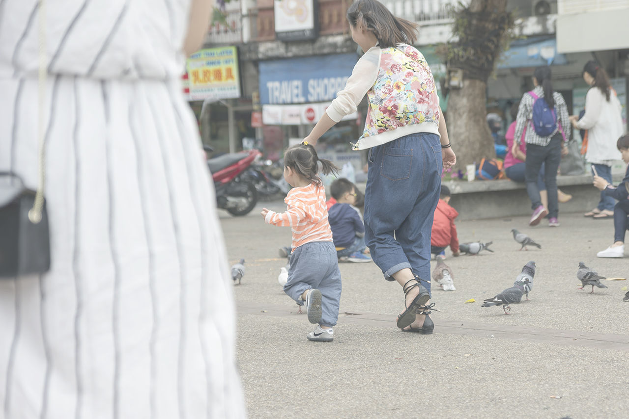 REAR VIEW OF CHILDREN STANDING OUTDOORS