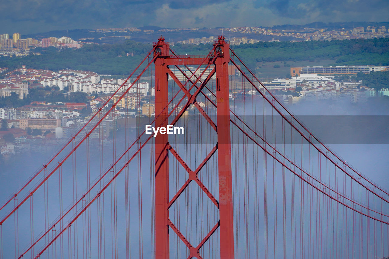 View of suspension bridge against cloudy sky. 25th april bridge, lisbon, portugal. 