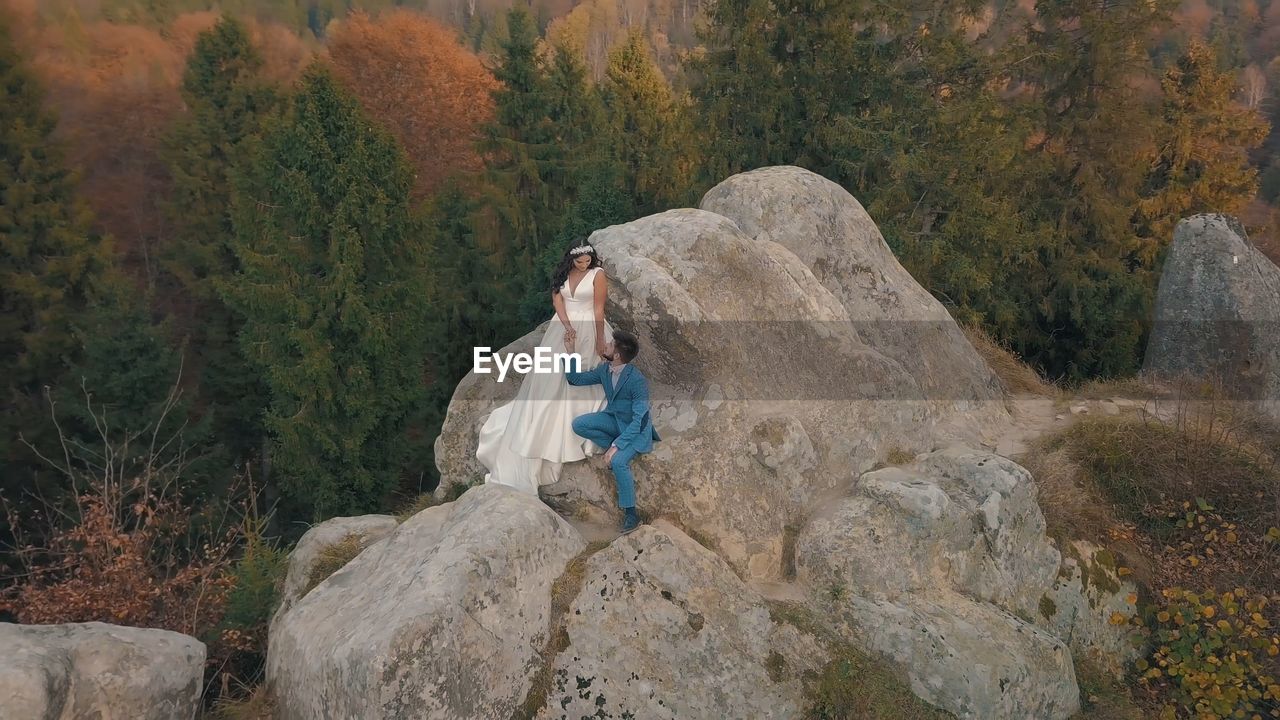 Full length of man on rock in forest