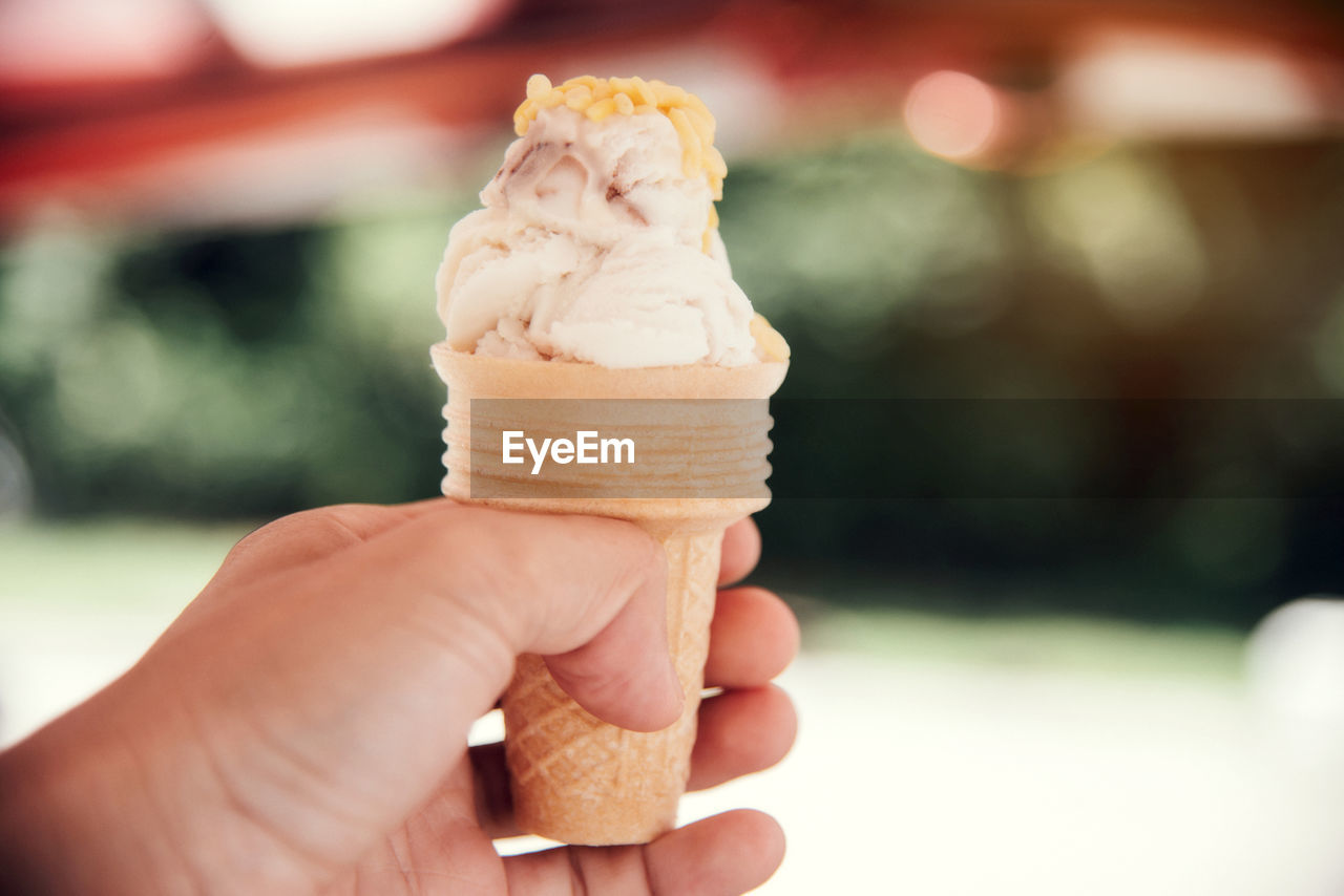 CROPPED IMAGE OF HAND HOLDING ICE CREAM CONE