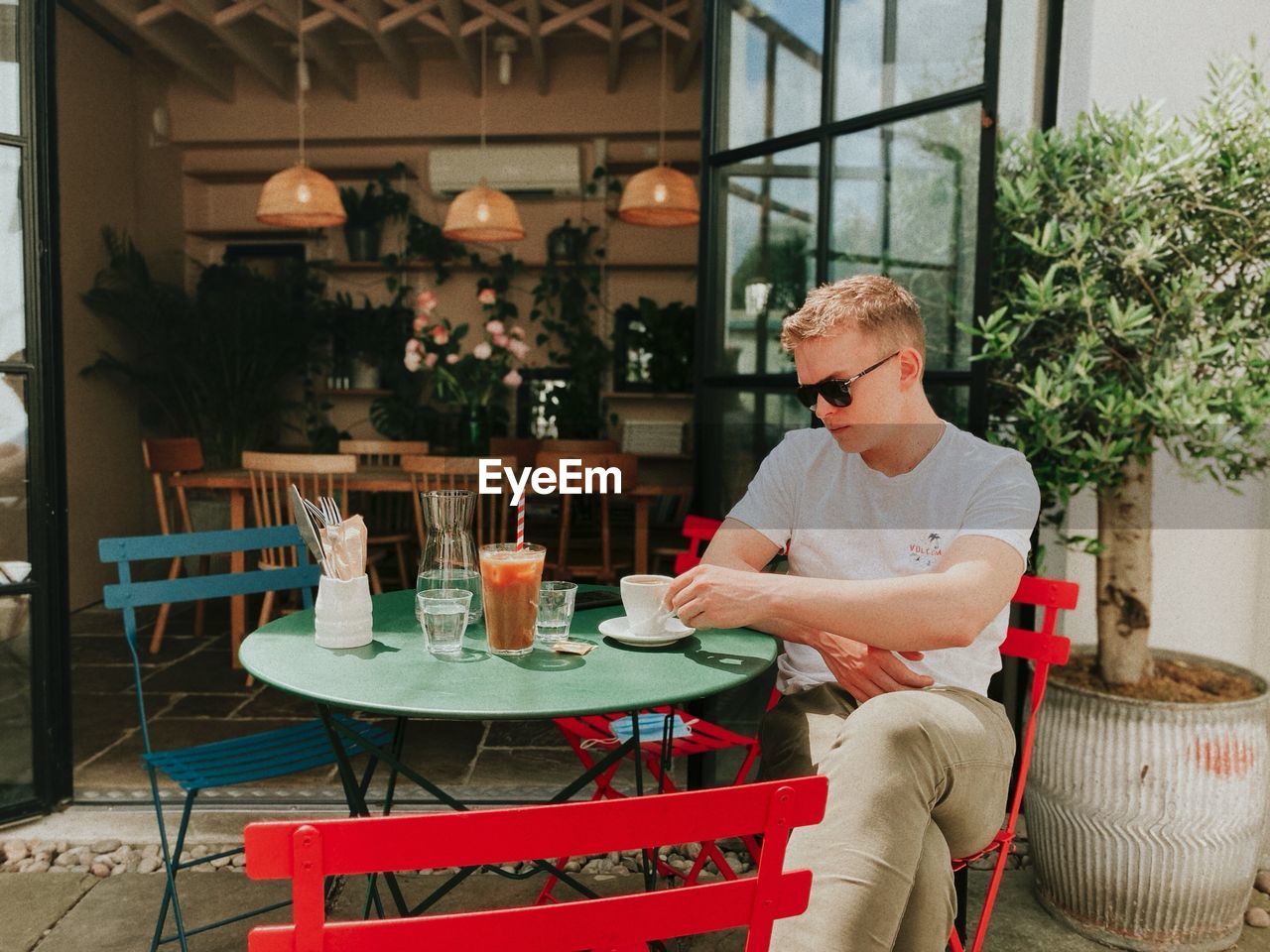 MAN SITTING ON TABLE AT CAFE