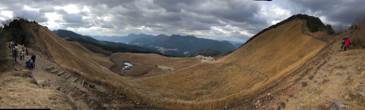 Panoramic view of mountains with people against sky