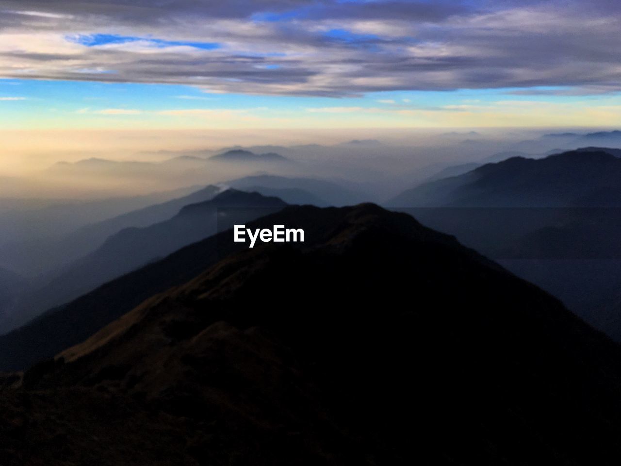 SCENIC VIEW OF CLOUDS OVER MOUNTAINS AGAINST SKY