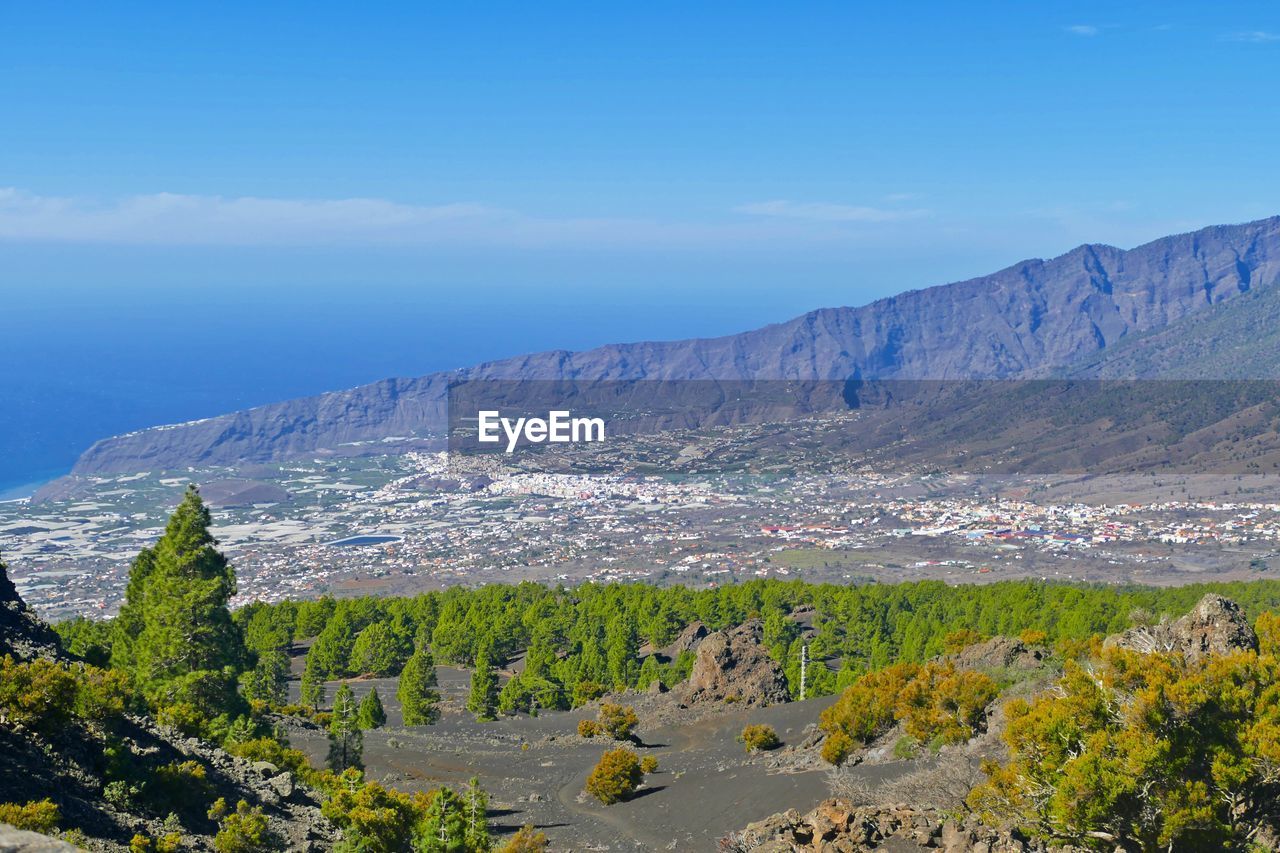 Scenic view of landscape and mountains against blue sky