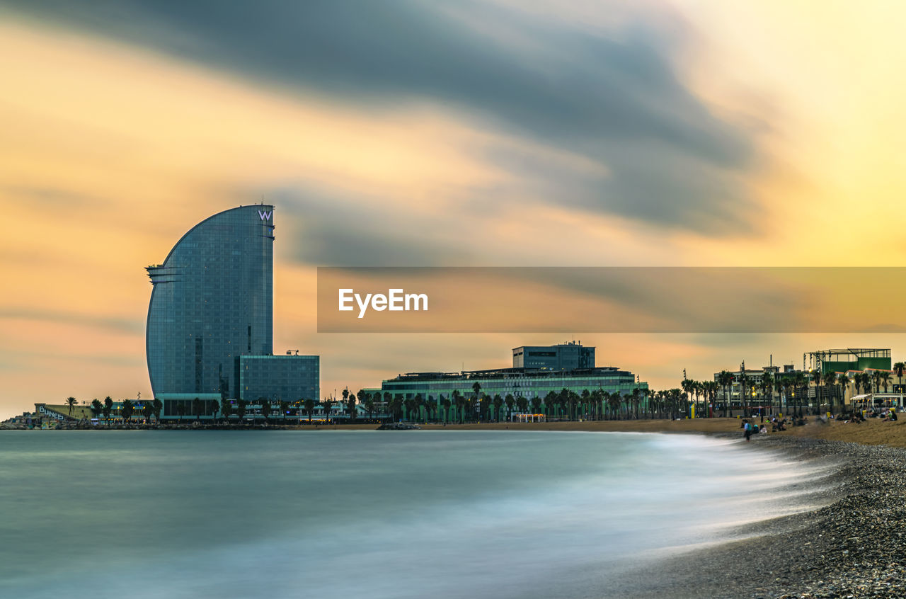 VIEW OF BUILDINGS AGAINST CLOUDY SKY