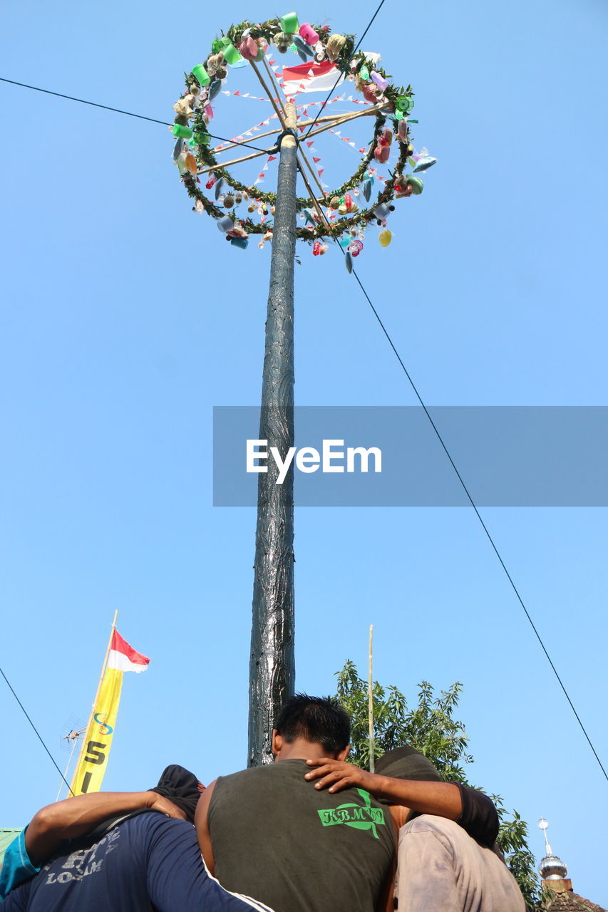 LOW ANGLE VIEW OF PEOPLE AT AMUSEMENT PARK AGAINST SKY