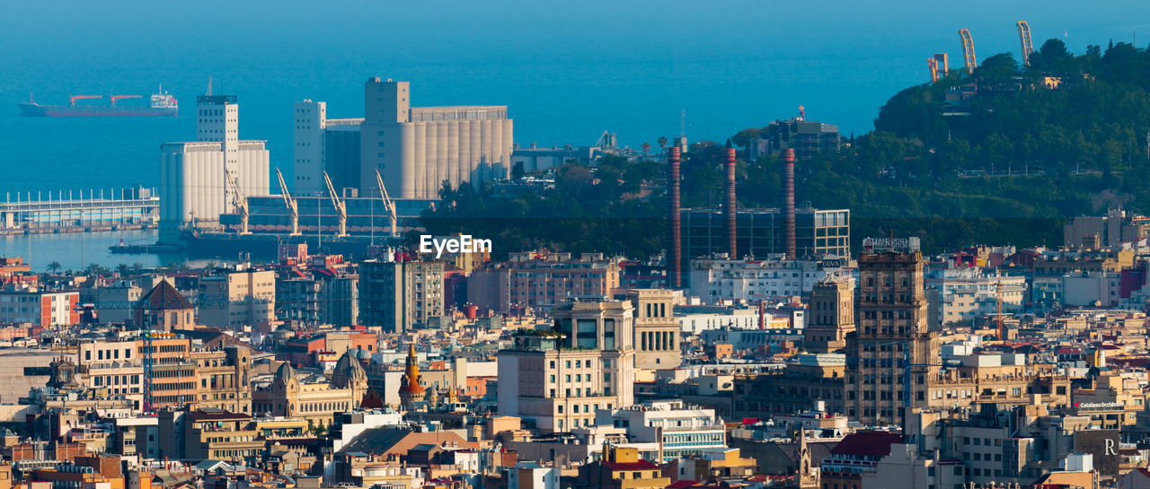 Aerial view of buildings in city against sky