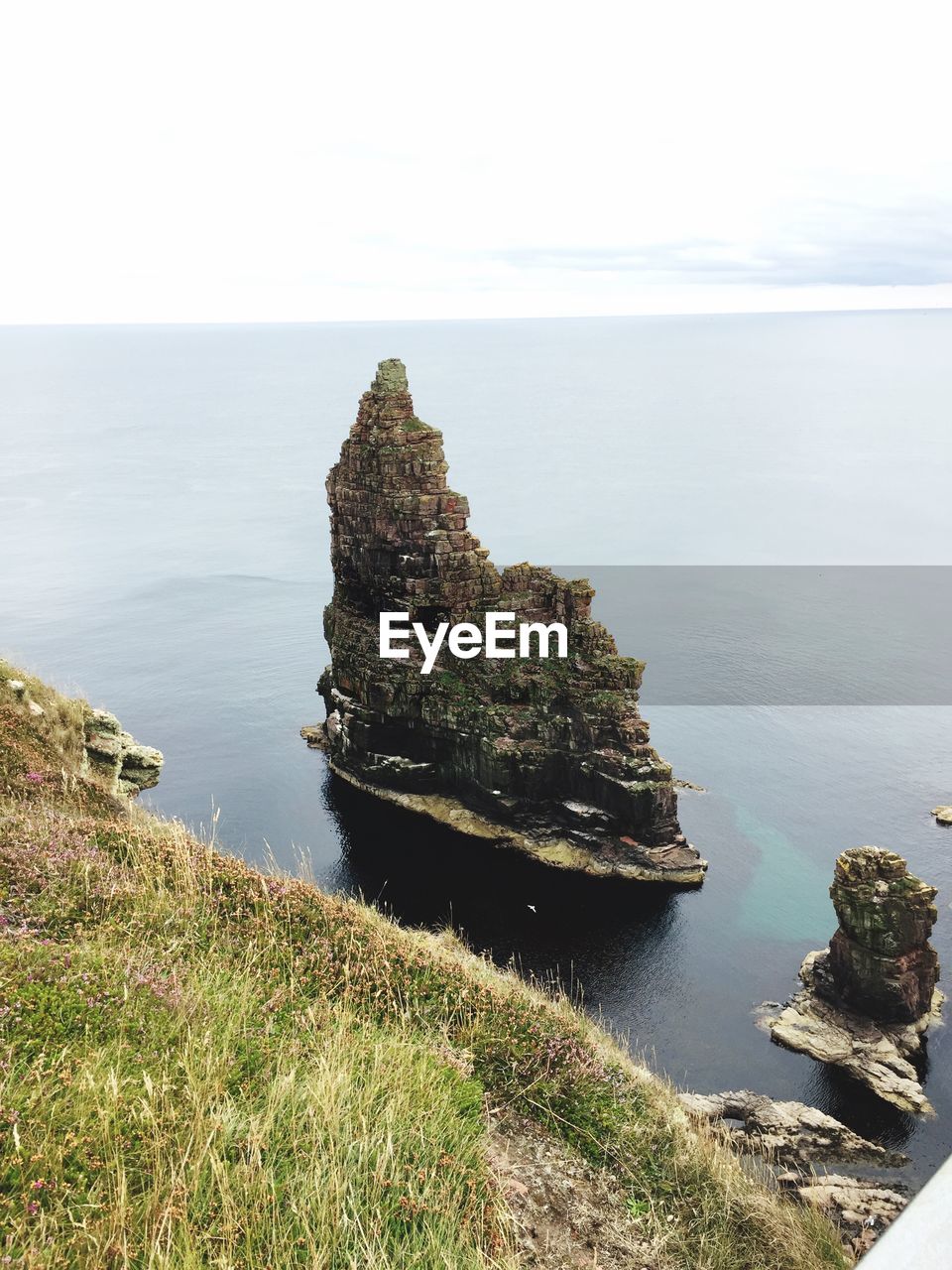 Rock formation on beach against sky