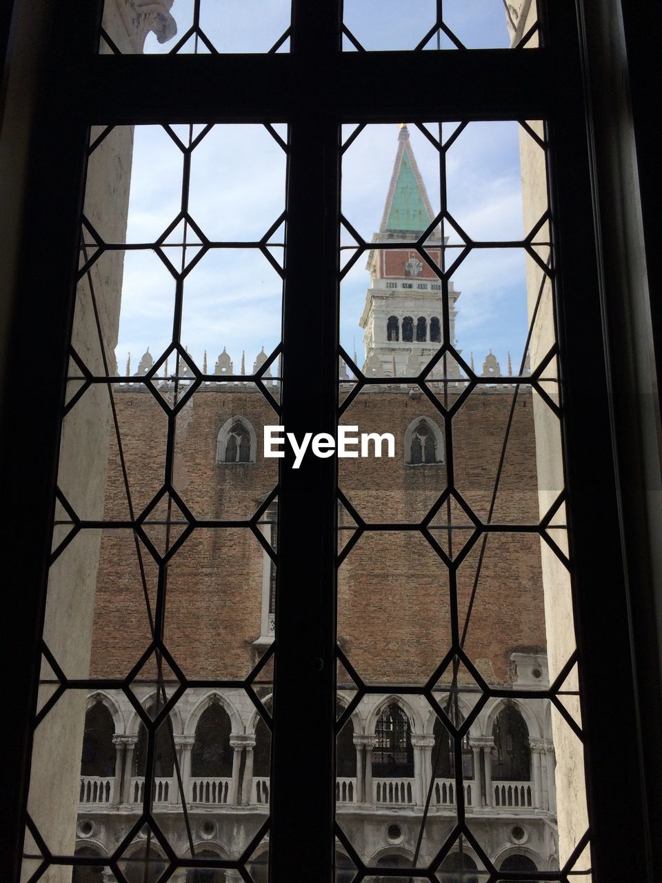 Clock tower seen through glass window