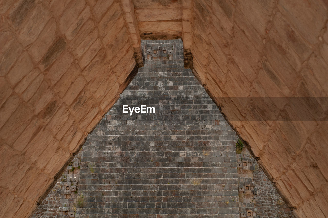 LOW ANGLE VIEW OF STONE WALL OF BUILDING