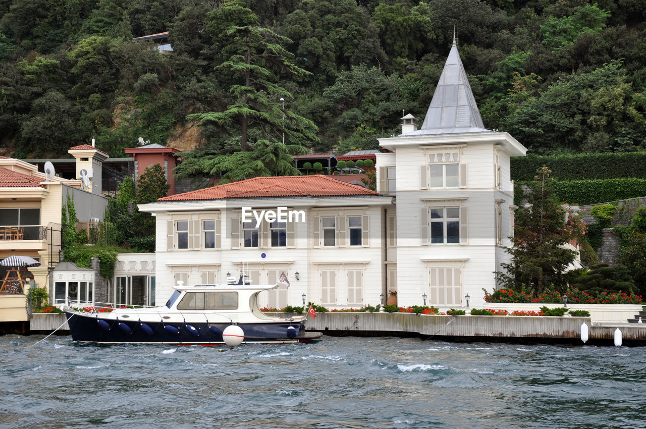 Building by sea against trees