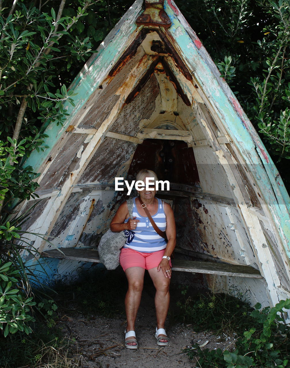 Portrait of woman smiling while sitting in abandoned boat