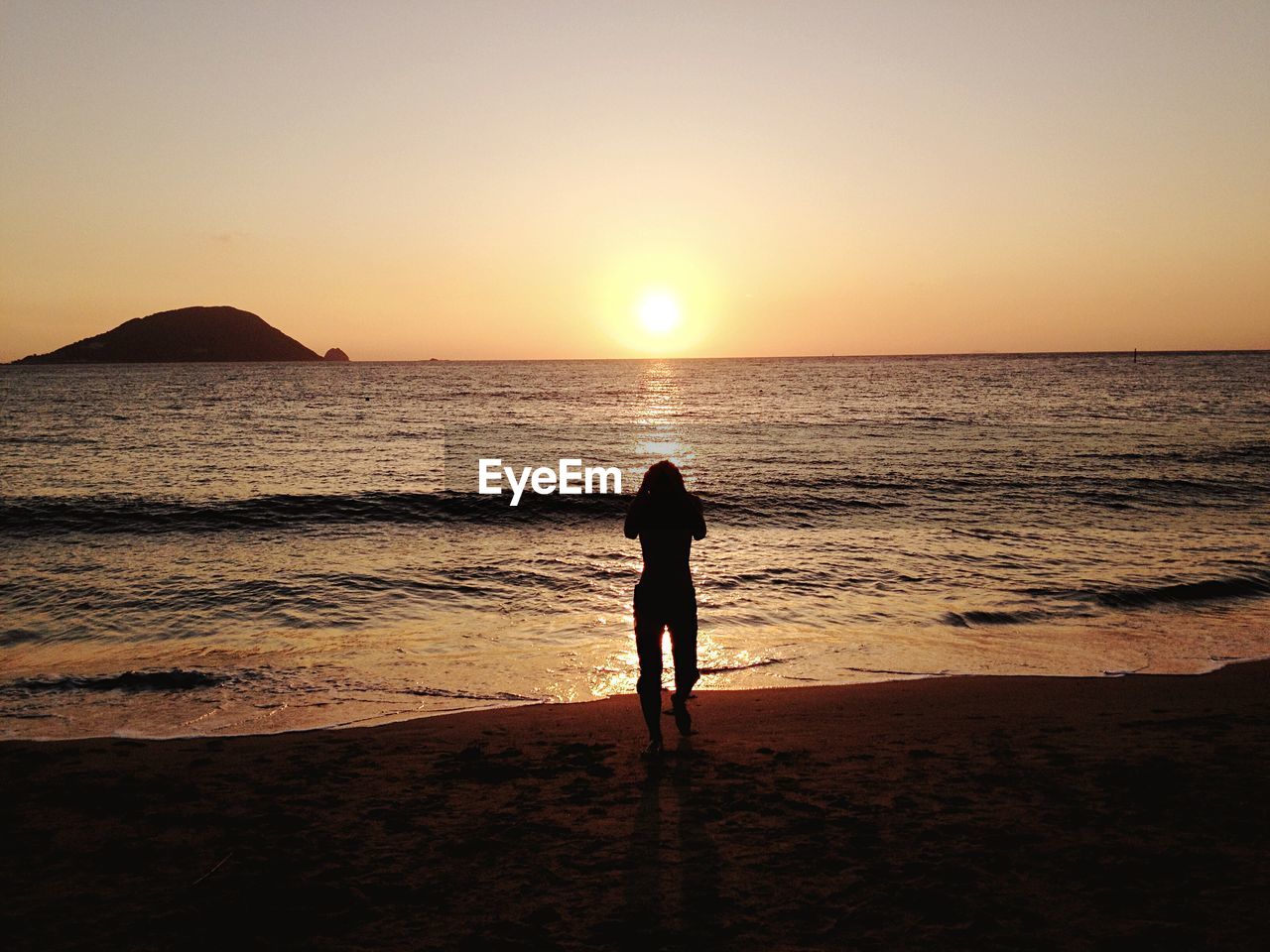 Silhouette person against sky during sunset on beach