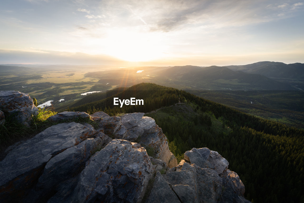 Sun rising on the horizon on a lovely spring day in mountains, prarie view trail, kananaskis, canada