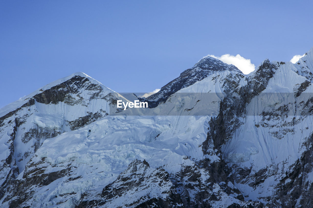 The summit of everest rises behind a ridge near the trail to base camp