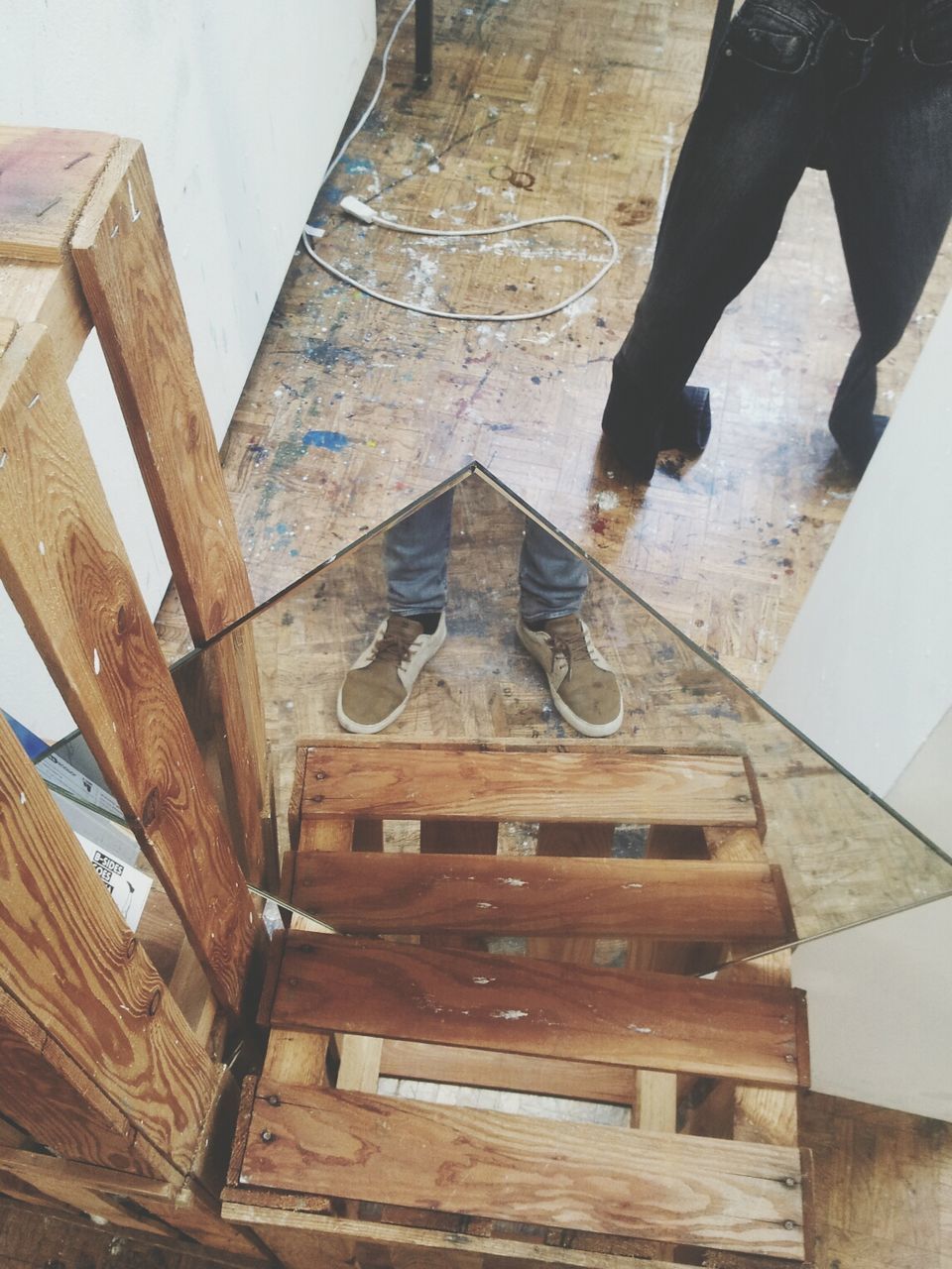 High angle view of jeans hanging in front of mirror in messy room