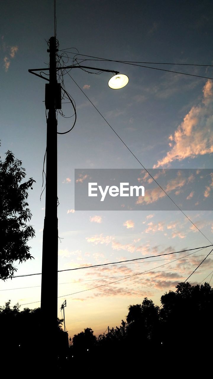 LOW ANGLE VIEW OF SILHOUETTE STREET LIGHT AND TREES AGAINST SKY