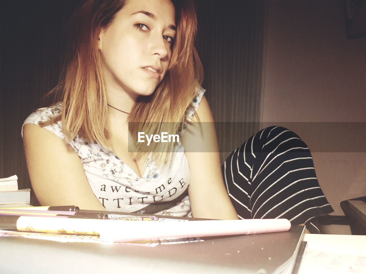 CLOSE-UP OF BEAUTIFUL YOUNG WOMAN SITTING ON TABLE WITH HANDS
