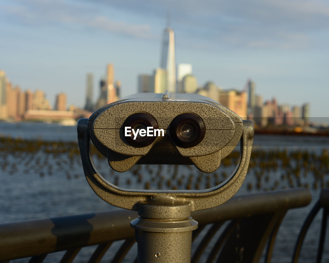 Close-up of coin-operated binoculars with buildings in backgrounds