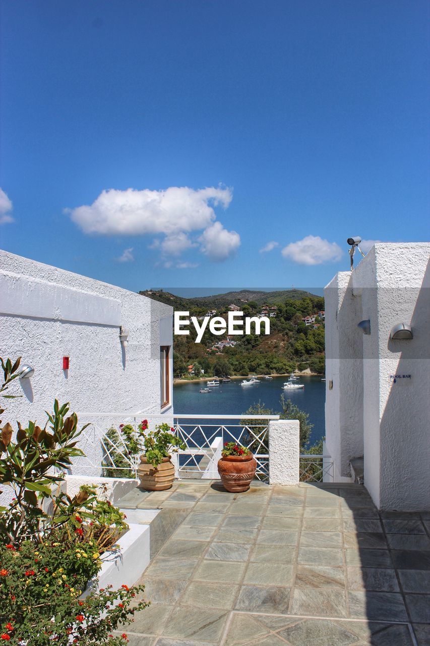 HOUSES BY SWIMMING POOL AGAINST SEA AND BUILDINGS