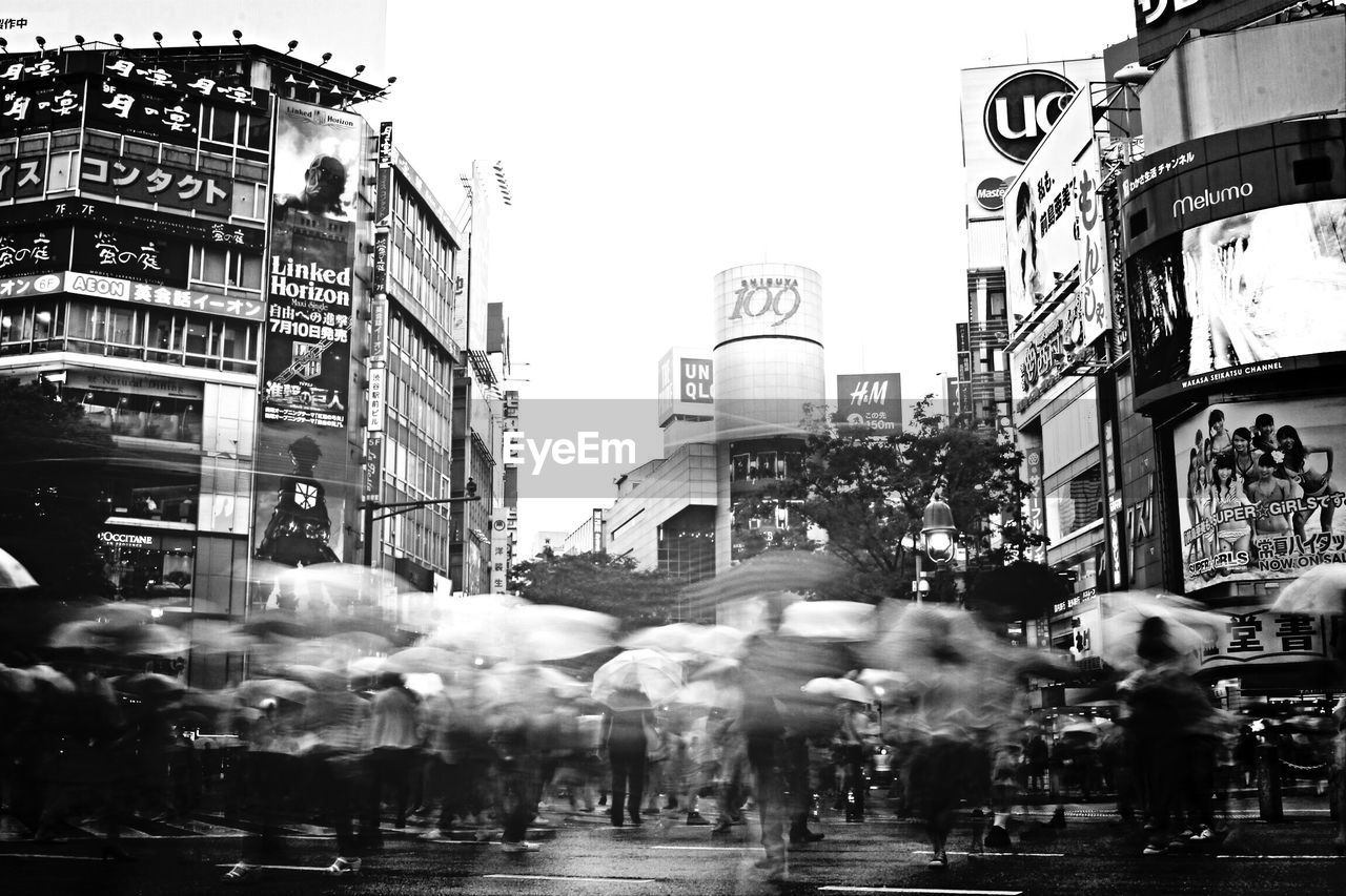 Blurred motion of people crossing street in city