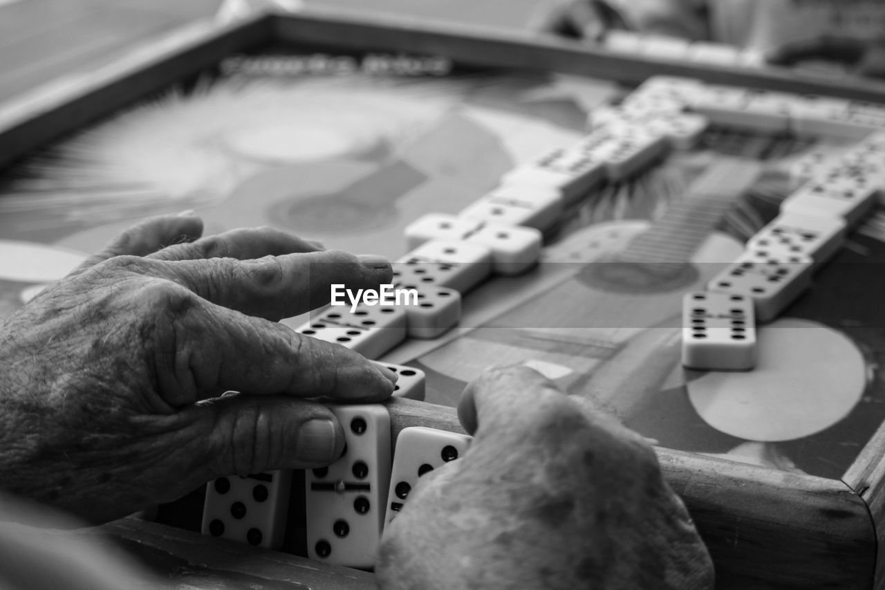 Cropped hand playing with dices on table