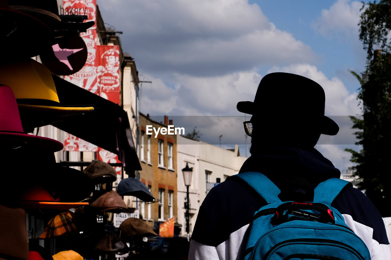 Rear view of man with bowler hat standing against sky