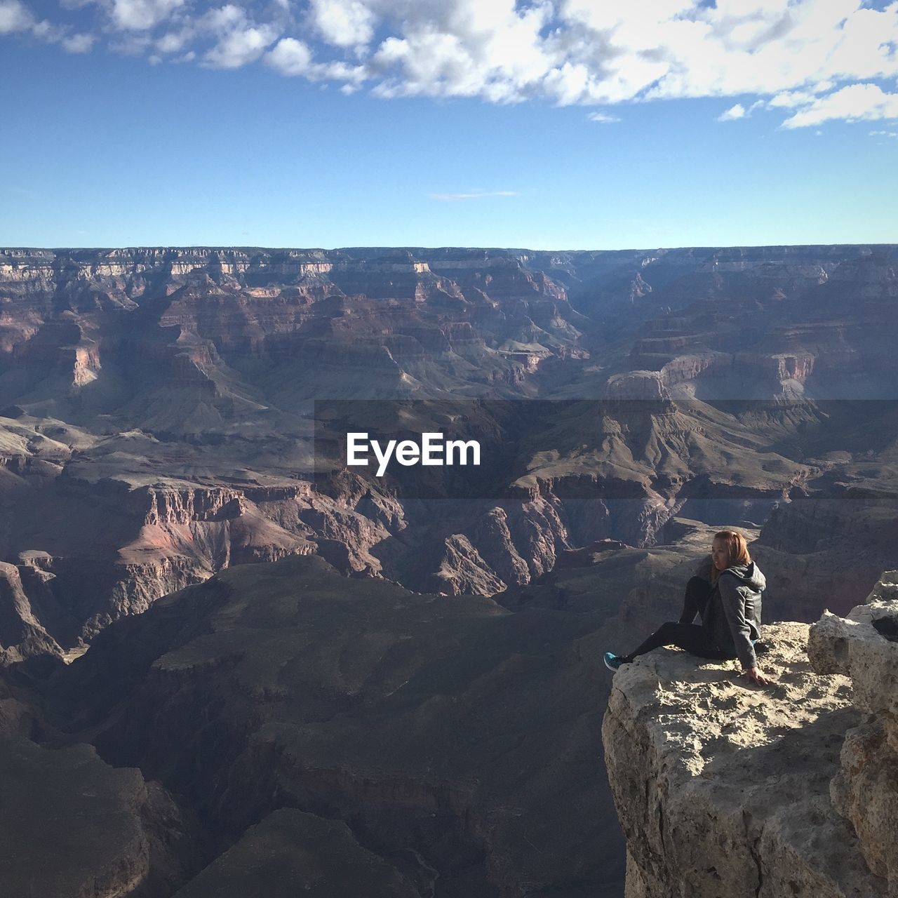 High angle view of woman sitting on cliff at grand canyon national park