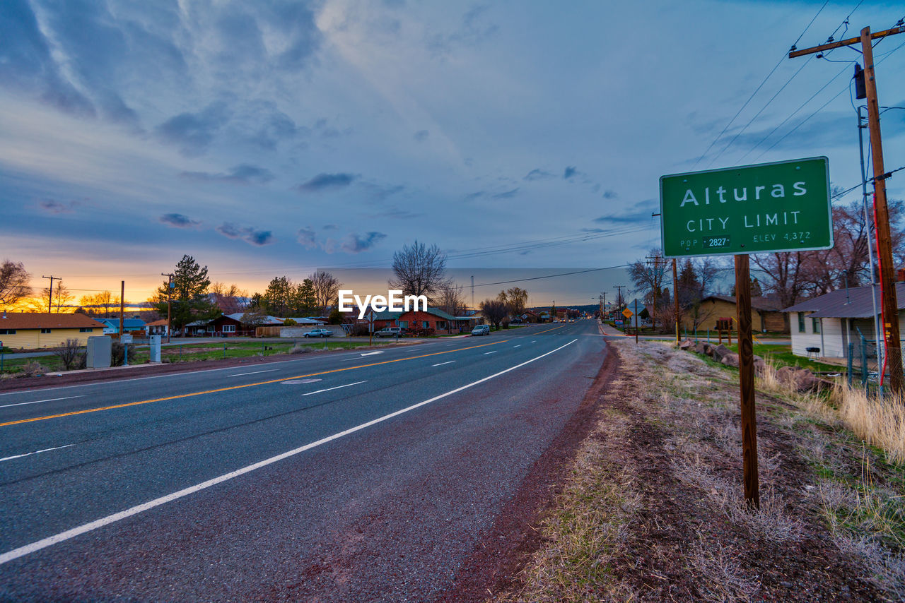 ROAD SIGN BY CITY AGAINST SKY