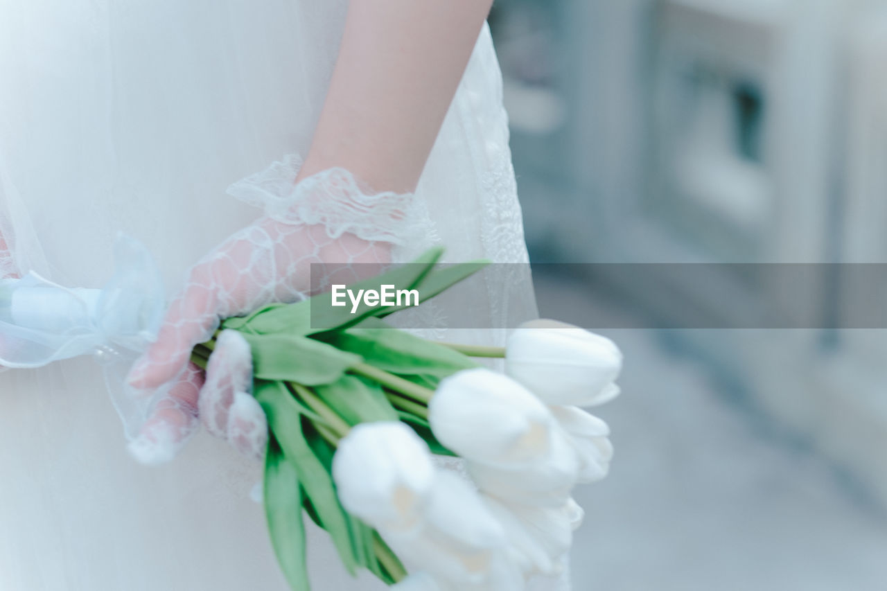 wedding, wedding dress, bride, newlywed, women, bouquet, event, one person, flower, adult, celebration, life events, flower arrangement, flowering plant, plant, holding, white, wedding ceremony, midsection, pink, close-up, dress, nature, indoors, hand, focus on foreground, clothing, freshness, married, fashion, ceremony, young adult, female, petal, gown, standing, beginnings, beauty in nature, spring, rose, love, day, bridal clothing, ribbon