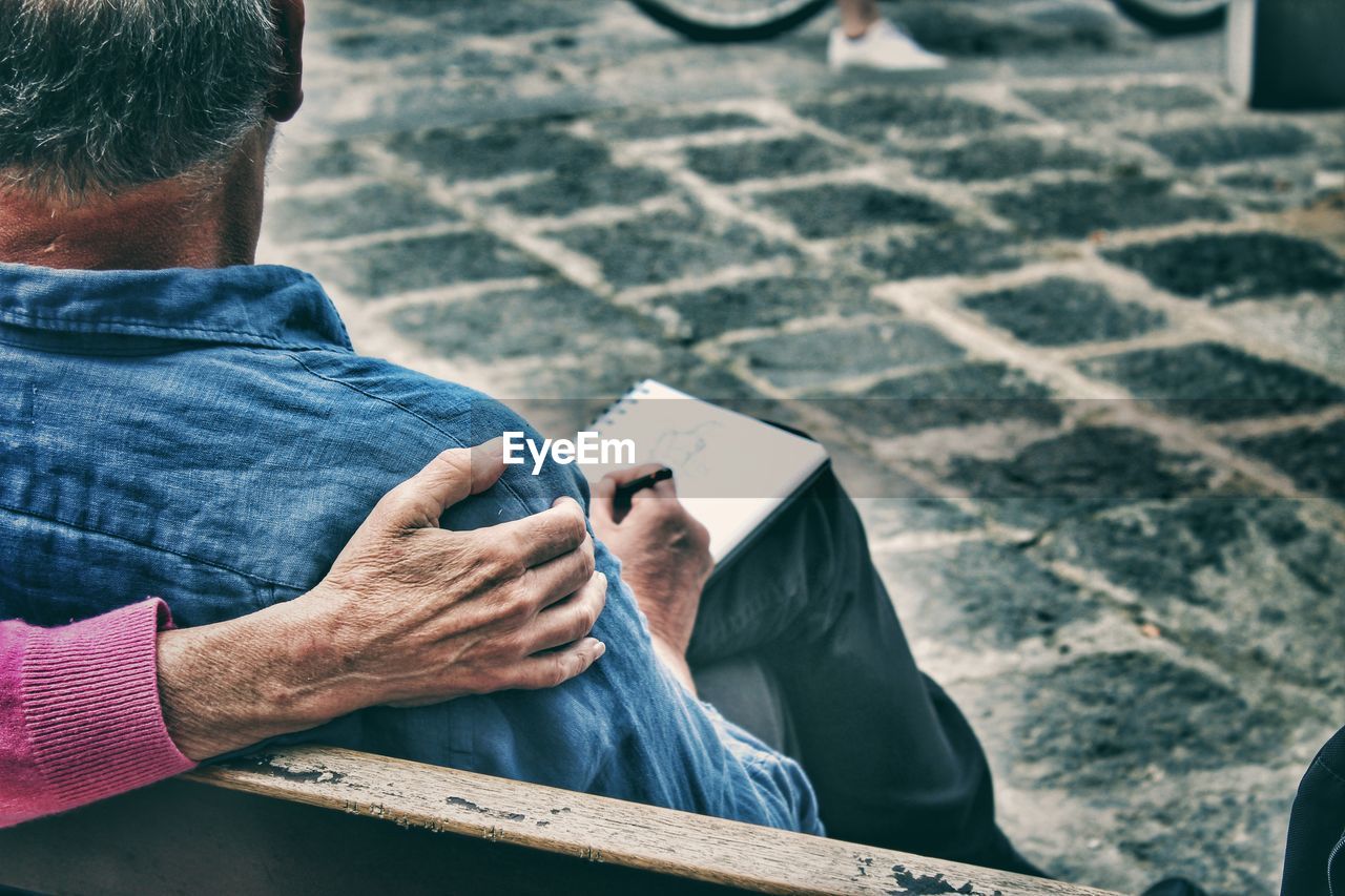 Rear view of man sitting on bench