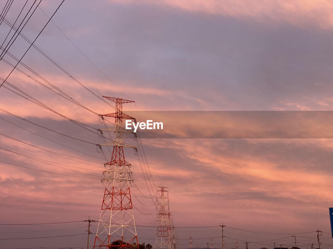 Low angle view of silhouette electricity pylon against sky during sunset