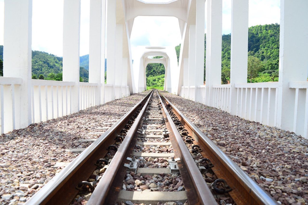 Railroad tracks amidst white columns