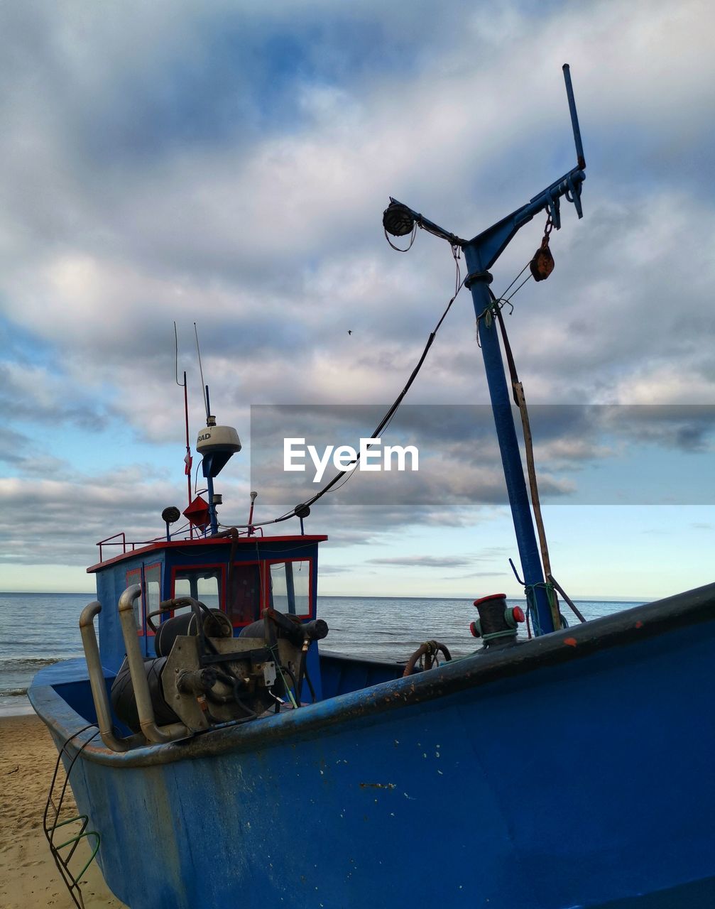 LOW ANGLE VIEW OF FISHING BOATS MOORED ON SEA AGAINST SKY