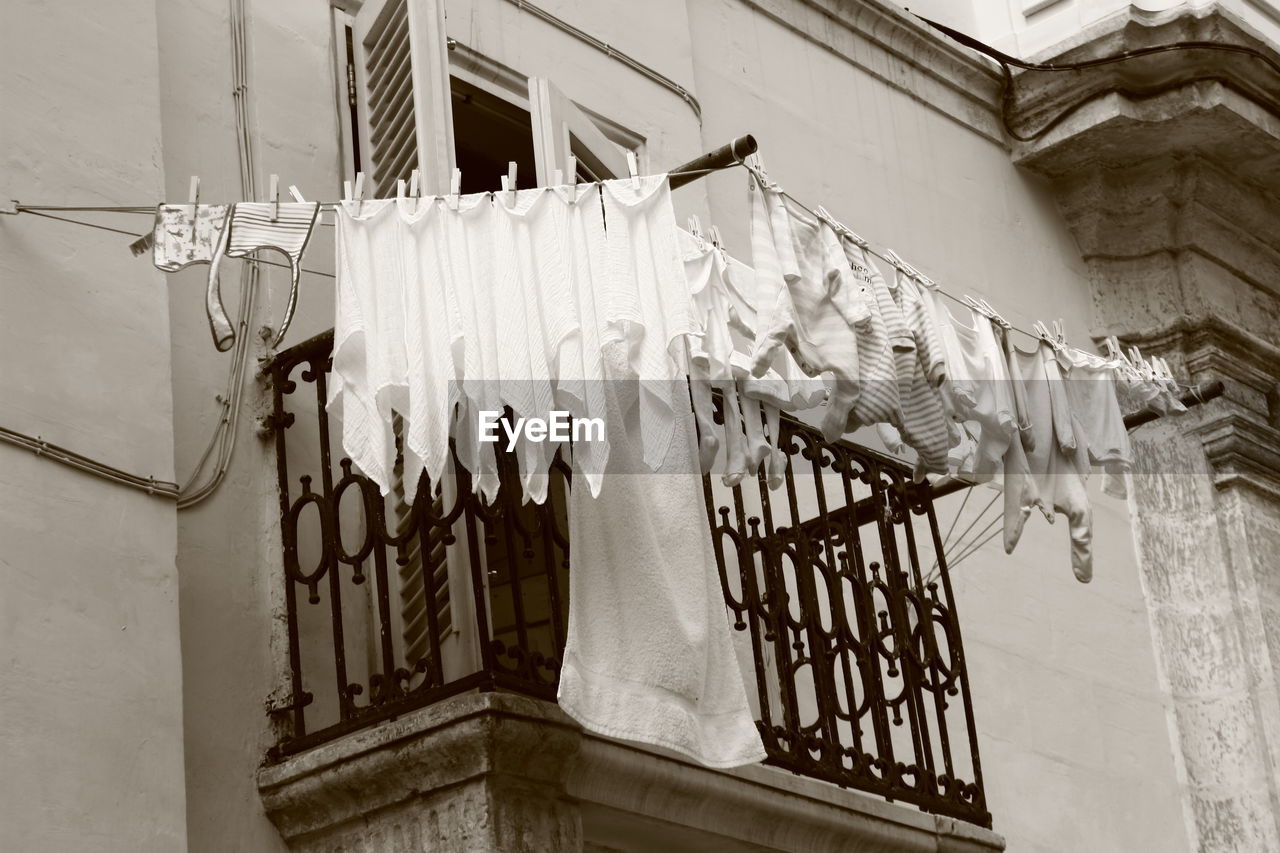 LOW ANGLE VIEW OF CLOTHES DRYING ON HOUSE