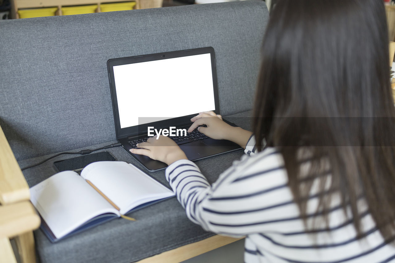 MIDSECTION OF WOMAN READING BOOK