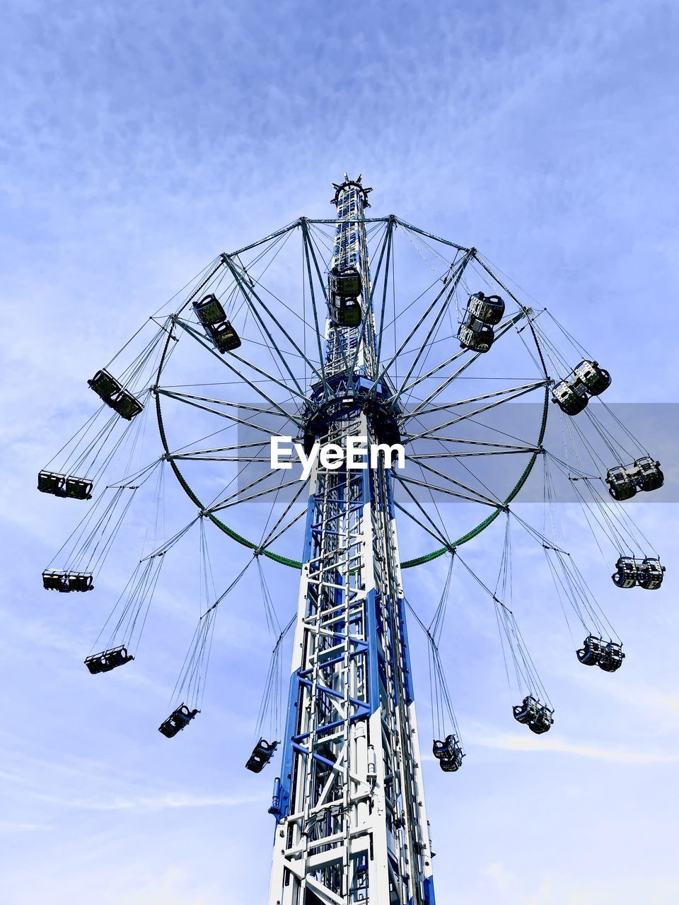 amusement park ride, amusement park, sky, ferris wheel, arts culture and entertainment, low angle view, nature, cloud, architecture, outdoors, spinning, carnival, fun, no people, built structure, day, traveling carnival, enjoyment, blue, chain swing ride, technology, geometric shape