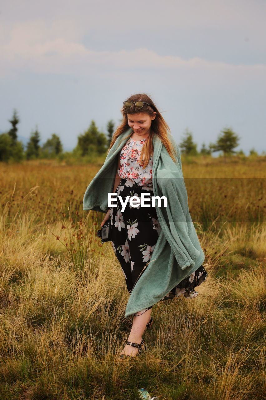 Woman standing on field against sky