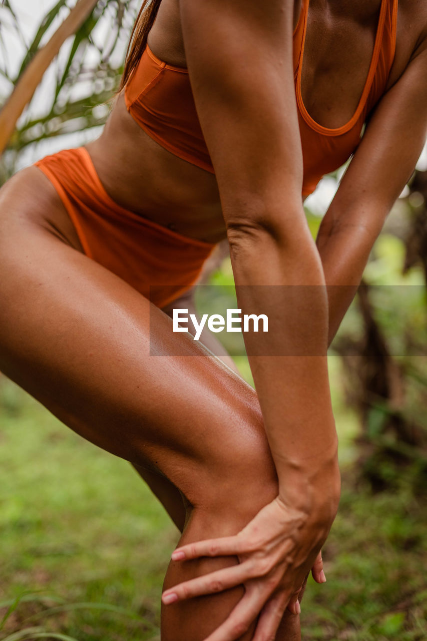 Low section of woman exercising on field