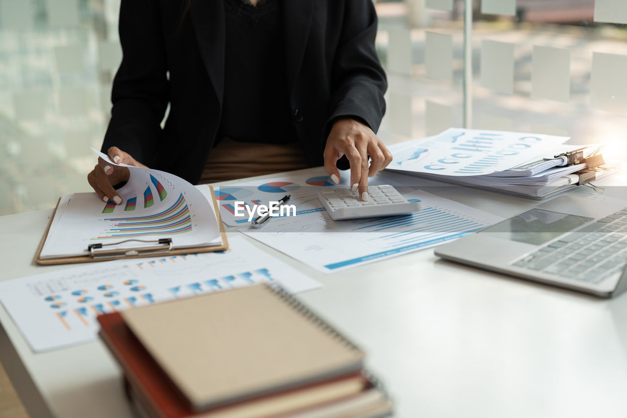 midsection of business people working at desk in office