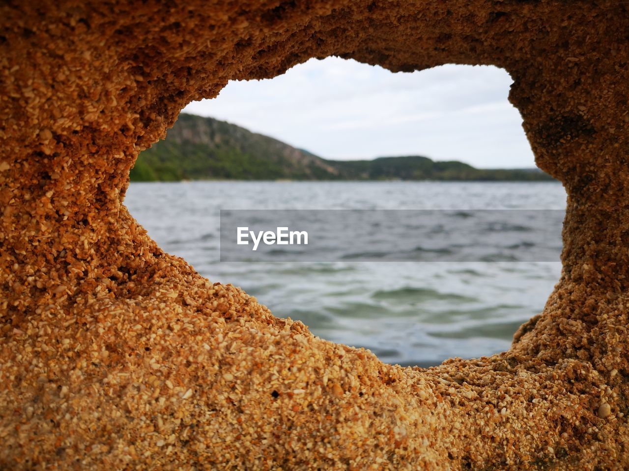 SCENIC VIEW OF SEA SEEN THROUGH ROCK