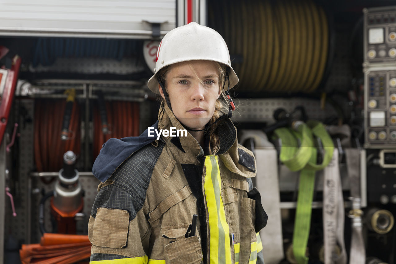 Female firefighter by fire engine