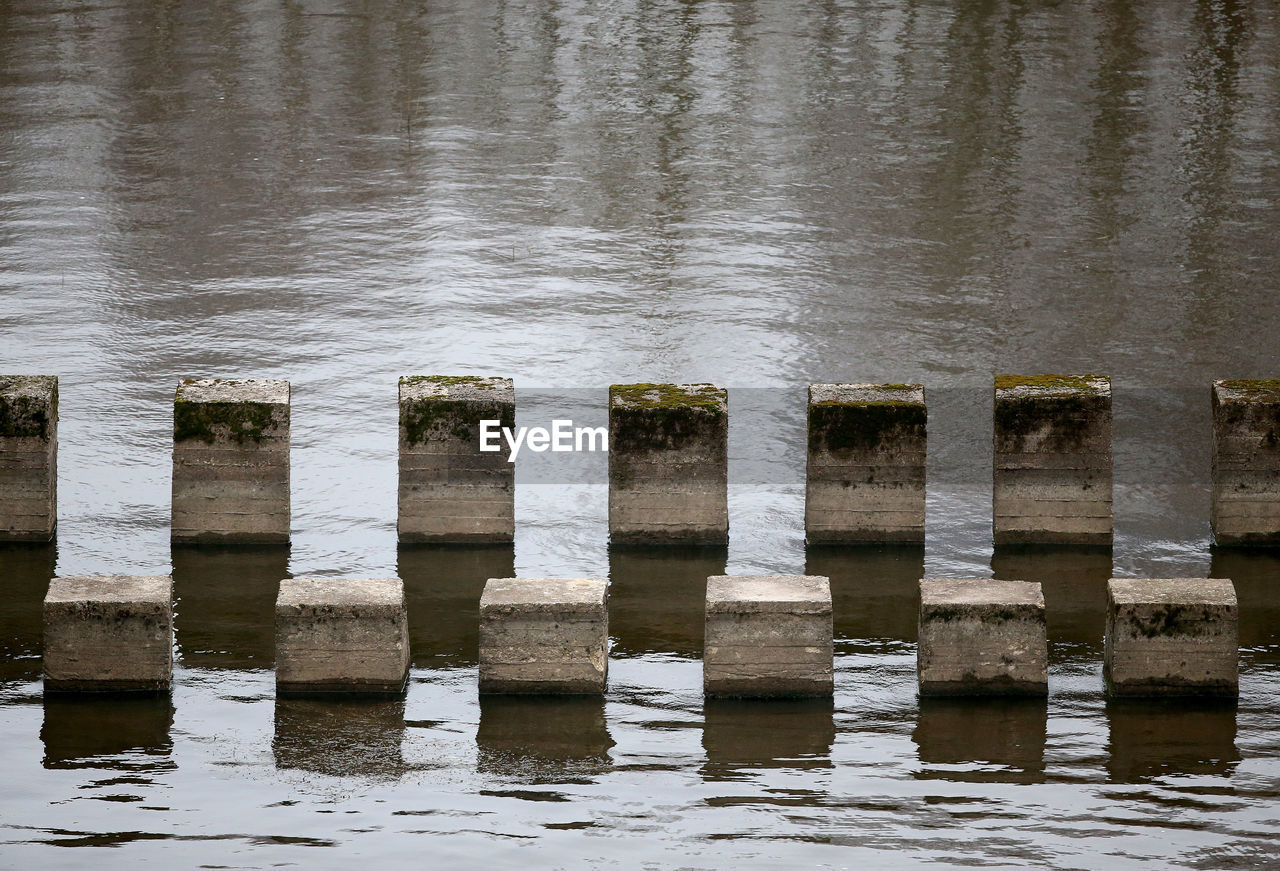 WOODEN POSTS ON LAKE