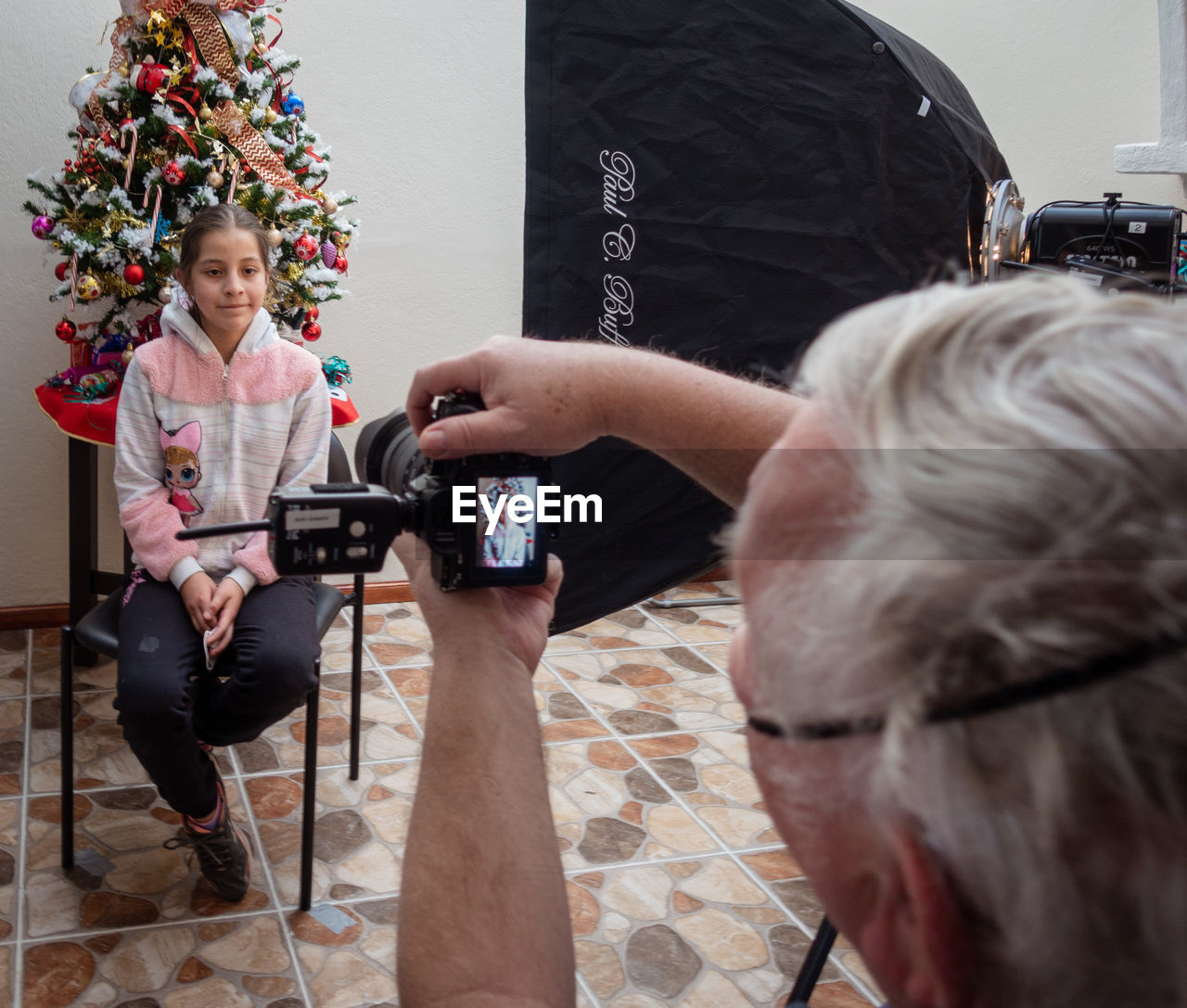 christmas tree, adult, women, person, sitting, indoors, female, two people, senior adult, men, holiday, clothing, celebration, christmas, plant, lifestyles, technology, holding, tree, communication, arts culture and entertainment, smiling, human face