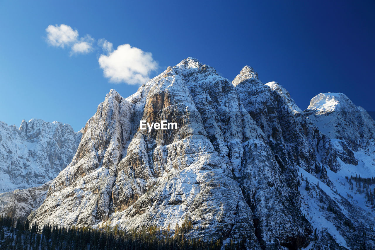 Scenic view of snowcapped mountains against blue sky