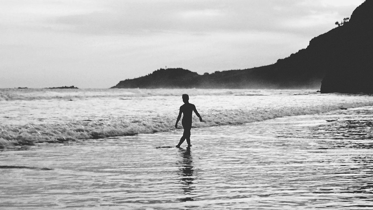 Silhouette man walking at beach