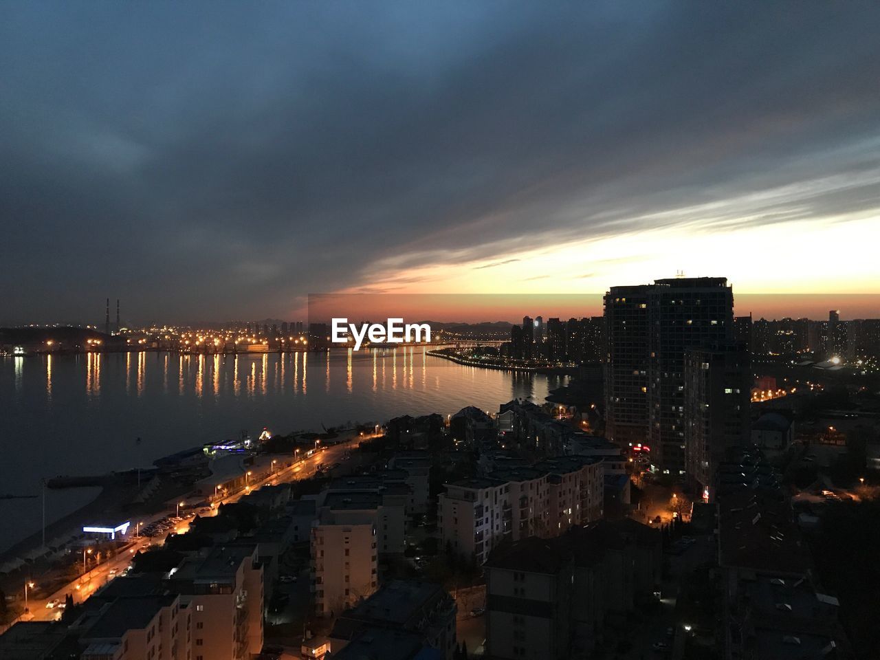 ILLUMINATED CITYSCAPE AGAINST SKY DURING SUNSET